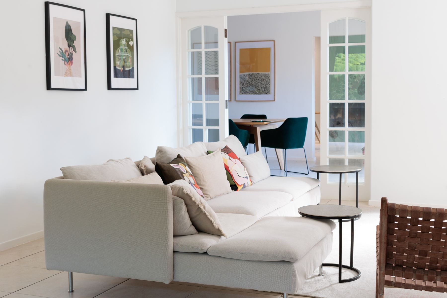 TV room with a white corner sofa and framed art