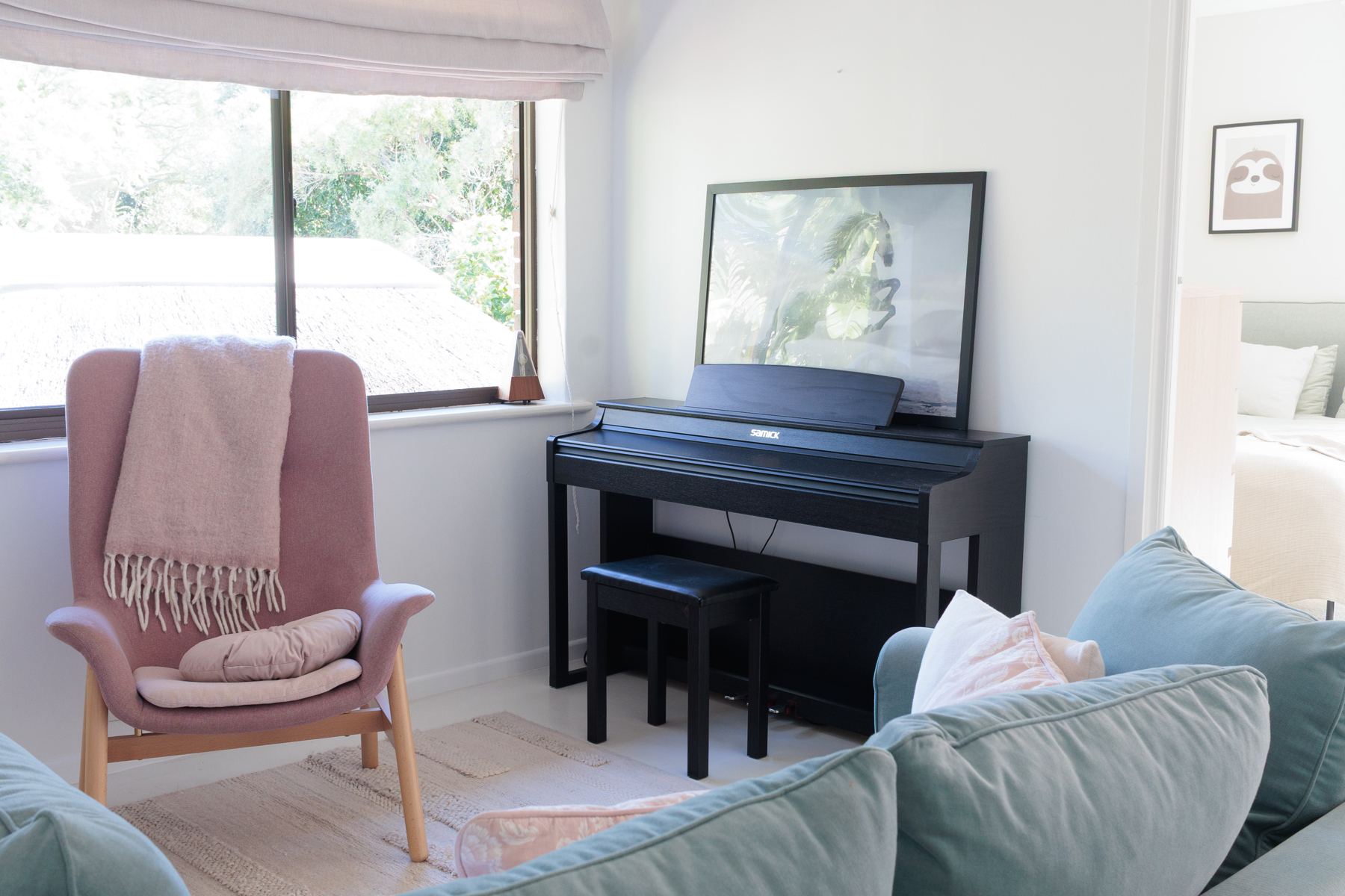 Upstairs lounge with a pink armchair and digital piano