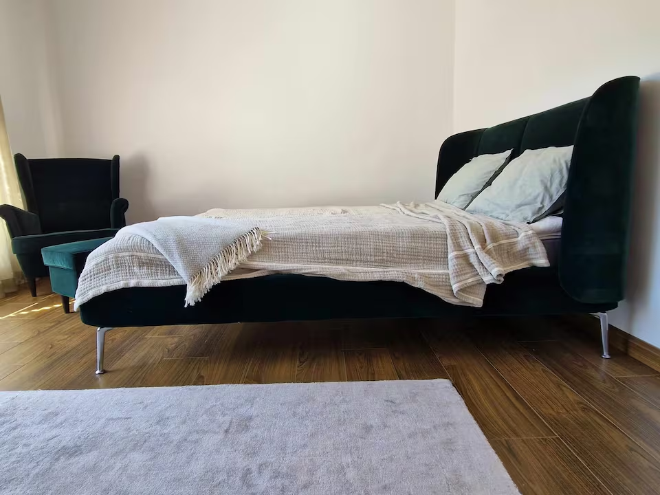 Bedroom with velvet bed and reading chair